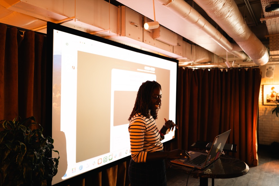 A member showing the room what they built during a Light School AI day