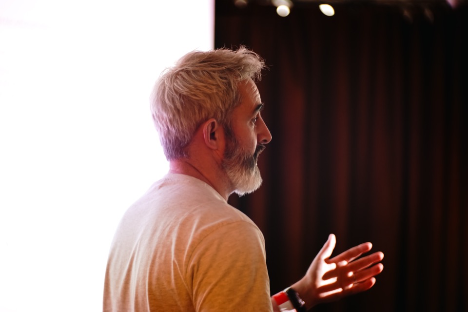 A speaker explaining an idea to the room at a Light School AI day